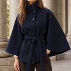 Woman wearing the belted cape coat in navy blue with a wide flowing silhouette