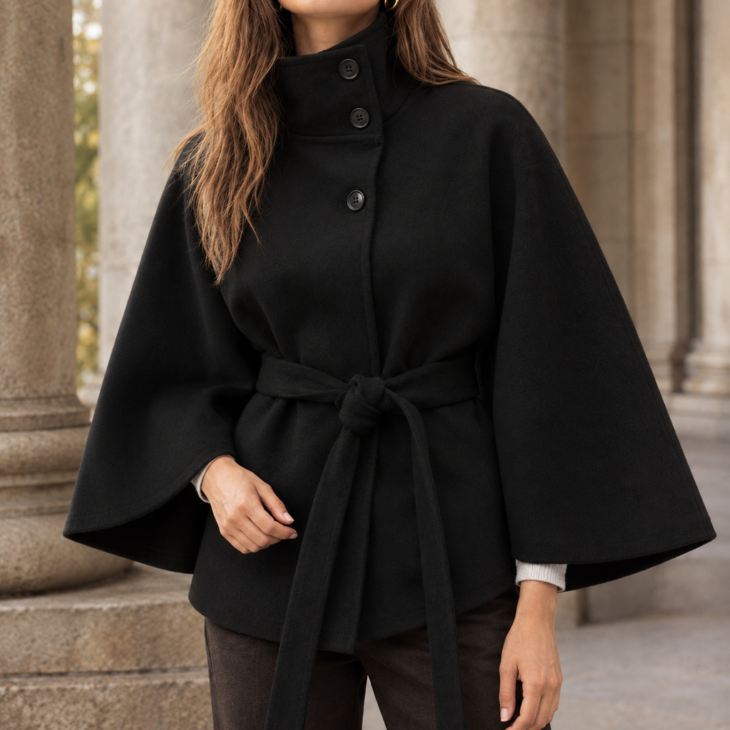 Woman wearing the belted cape coat in black with an asymmetric stand collar