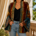 Woman wearing a burgundy boho kimono jacket with an ornate pattern and long bell sleeves