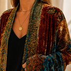 Close view of the burgundy kimono jacket showing the ornate woven pattern