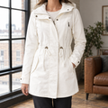 Woman wearing a white hooded parka with an asymmetric zip and drawstring waist