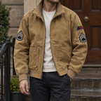 Aviator Jacket in Brown showing the embroidered sleeve patches and ribbed collar.