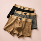 Three boxer briefs in tan, gray and black with wide tan elastic waistbands.