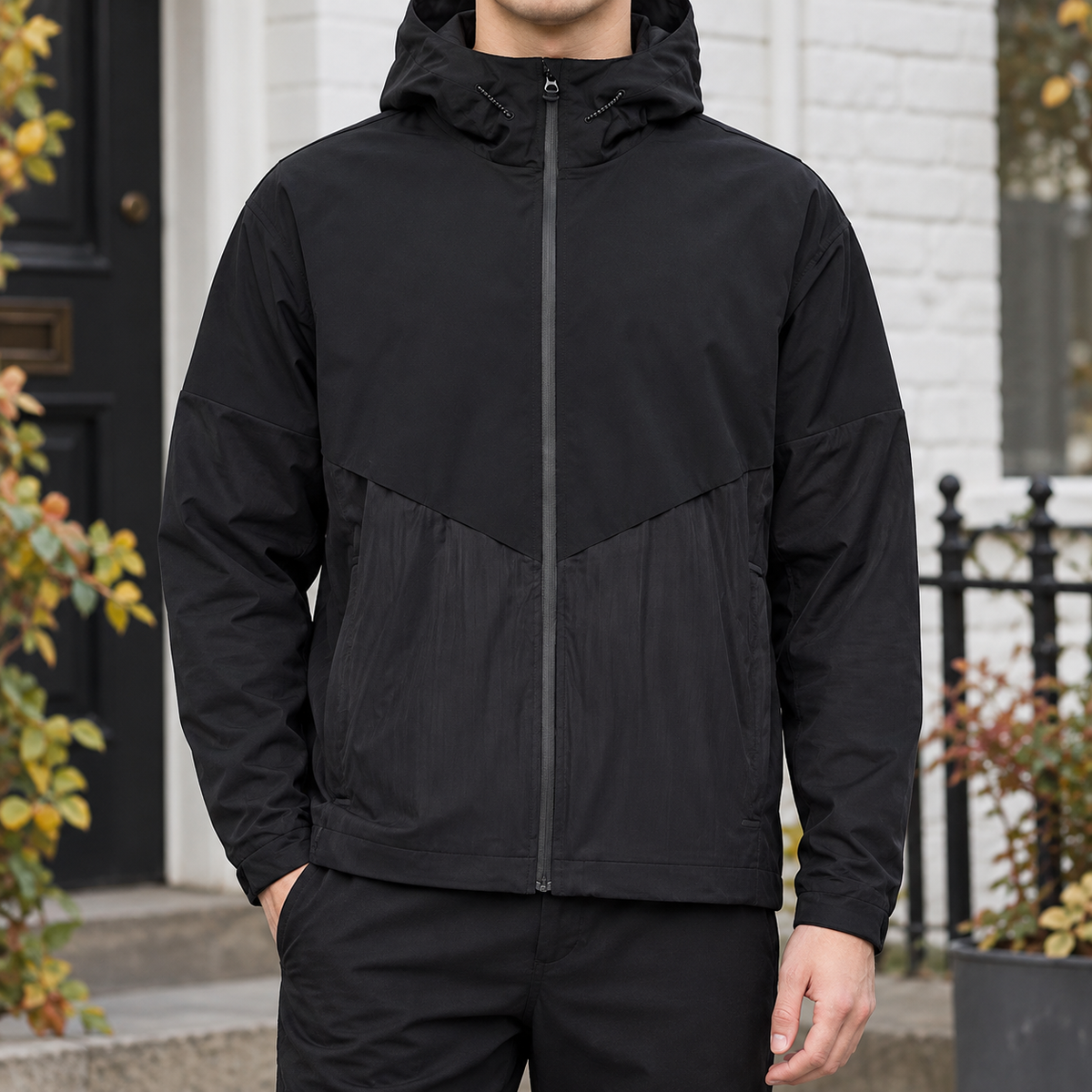 Hooded Jacket in Black showing the drawcord hood, chevron yoke, and relaxed fit.