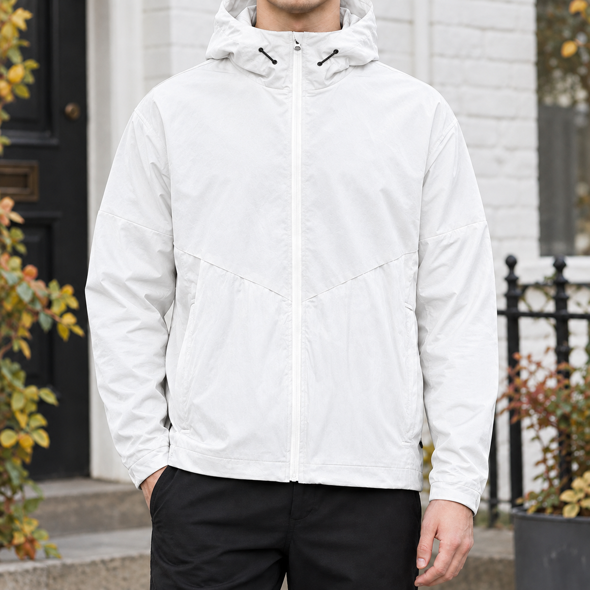 Hooded Jacket in White showing the drawcord hood, chevron yoke, and relaxed fit.