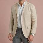 Cream mens linen blend blazer with notch lapels and flap pockets, worn over a pale shirt.