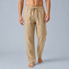 Cream drawstring trousers worn walking with bare feet and bare torso cropped above waist