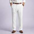 White mens linen trousers with front pleats and belt loops, worn with a brown belt and loafers.