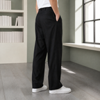 Black full length pleated pants with rear pockets, shown from the back with white shoes.