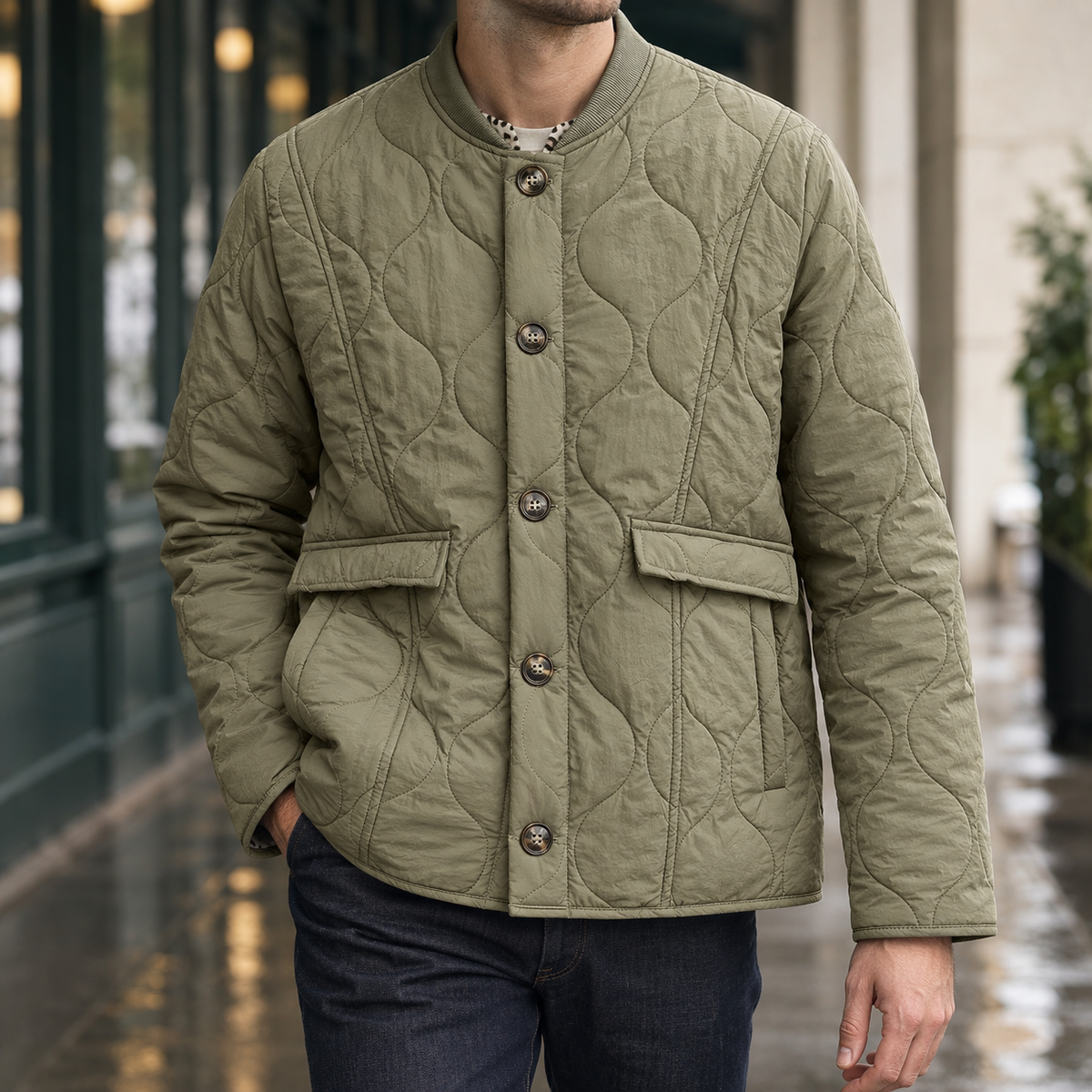 Quilted Jacket in Olive Green showing the wavy quilting, ribbed round collar, and side-entry pockets.
