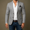 Gray mens tailored blazer with notch lapels and flap pockets, worn over a white shirt.