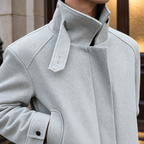 Belted Jacket detail view 2 showing the wool construction, asymmetric front, and adjustable waist strap.