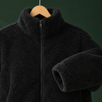 Close view of the black plush jacket showing its textured pile and full zip fastening