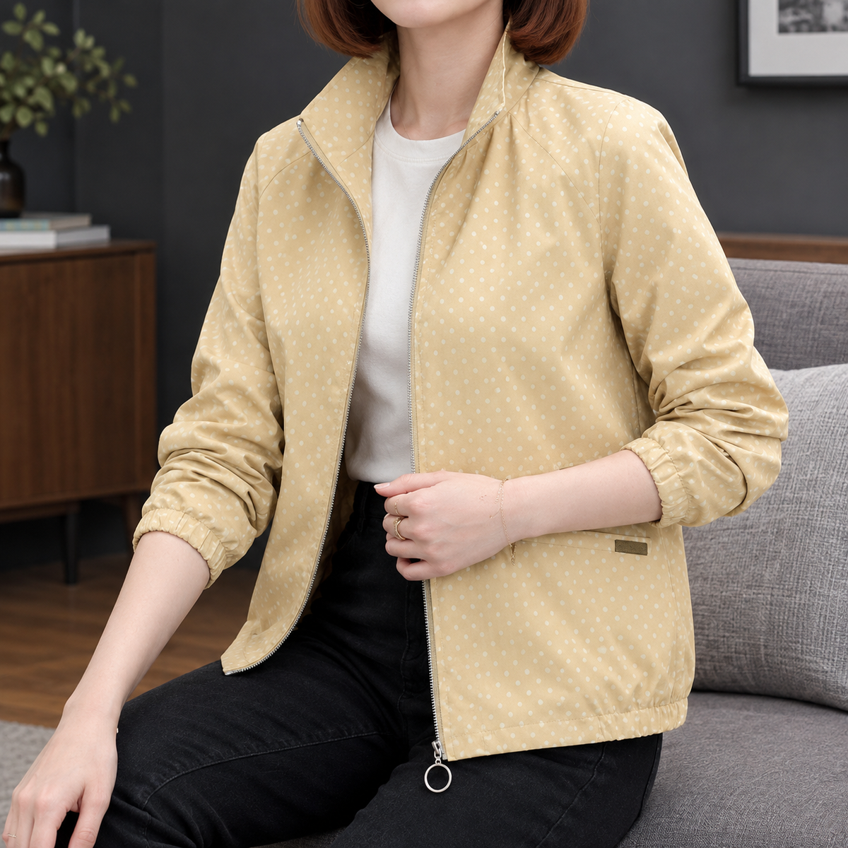Woman wearing a yellow polka dot zip jacket with a stand collar and elasticated edges
