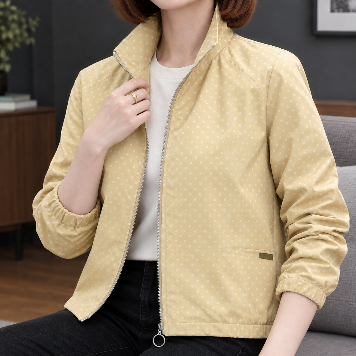 Close view of the yellow polka dot jacket showing its full zip and printed fabric