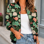 A woman wears a green printed bomber jacket with a botanical pattern, front zip and ribbed trim.