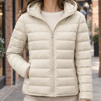 Close view of the apricot quilted jacket showing its padded hood and stitched construction