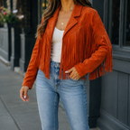 Orange cropped fringe jacket with an open front worn with jeans.