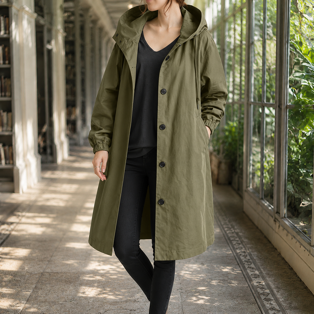 Green hooded overcoat with a button front on a model.