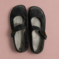 Black Mary Jane shoes with cross straps and round buttons, viewed from above.