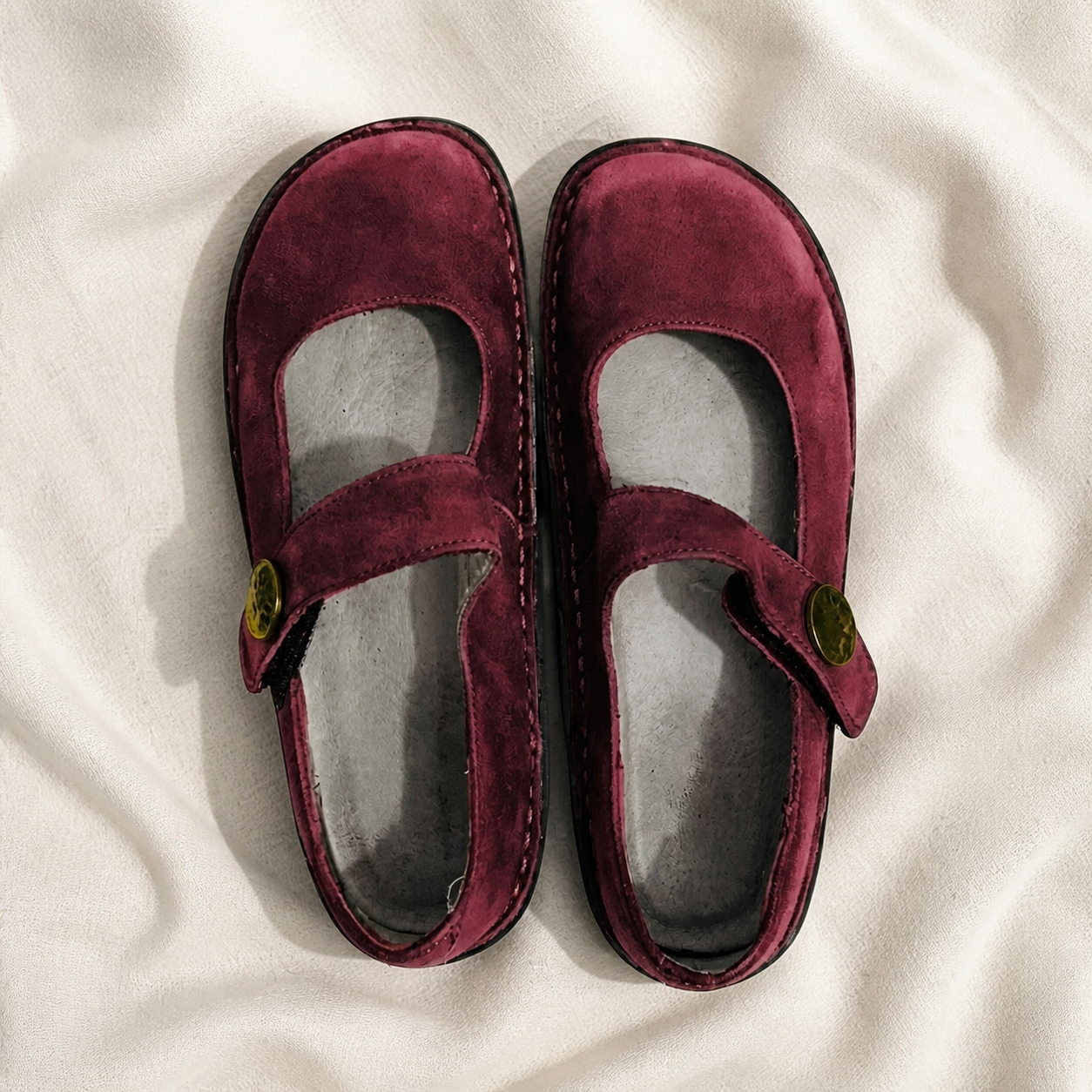 Burgundy Mary Jane shoes with cross straps, viewed from above.