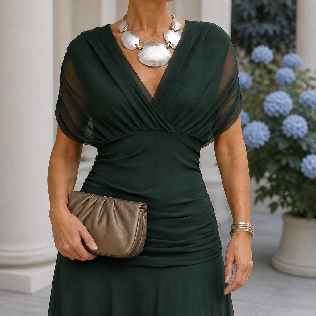Green draped dress with a crossover neckline and sheer short sleeves.