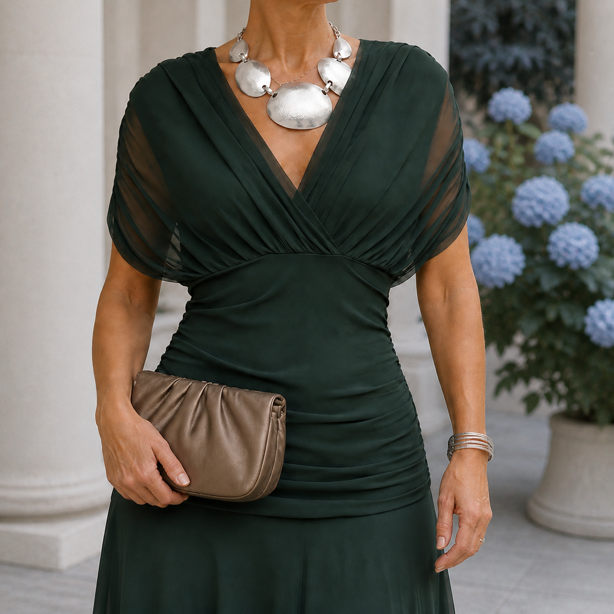 Green draped dress with a crossover neckline and sheer short sleeves.