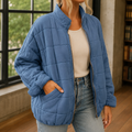 Blue oversized quilted jacket with a zip front.