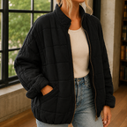 Black oversized quilted jacket with a zip front.