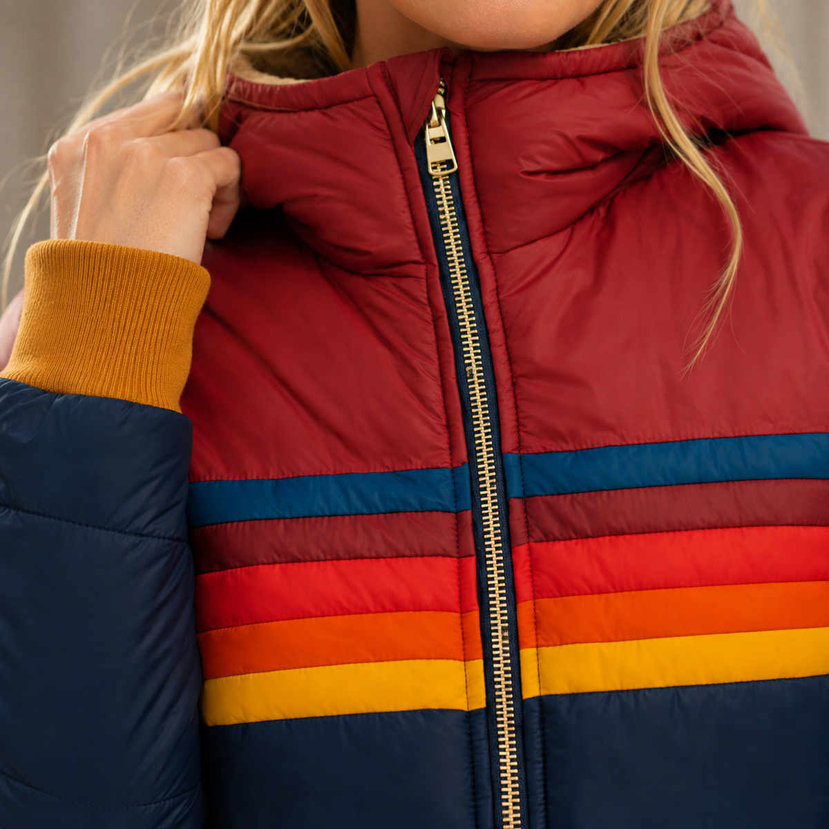 Detail of the dark blue jacket's colorful chest stripes and zip.