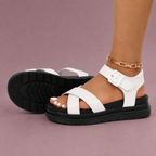 White sandals showing the side profile and black outsole tread.