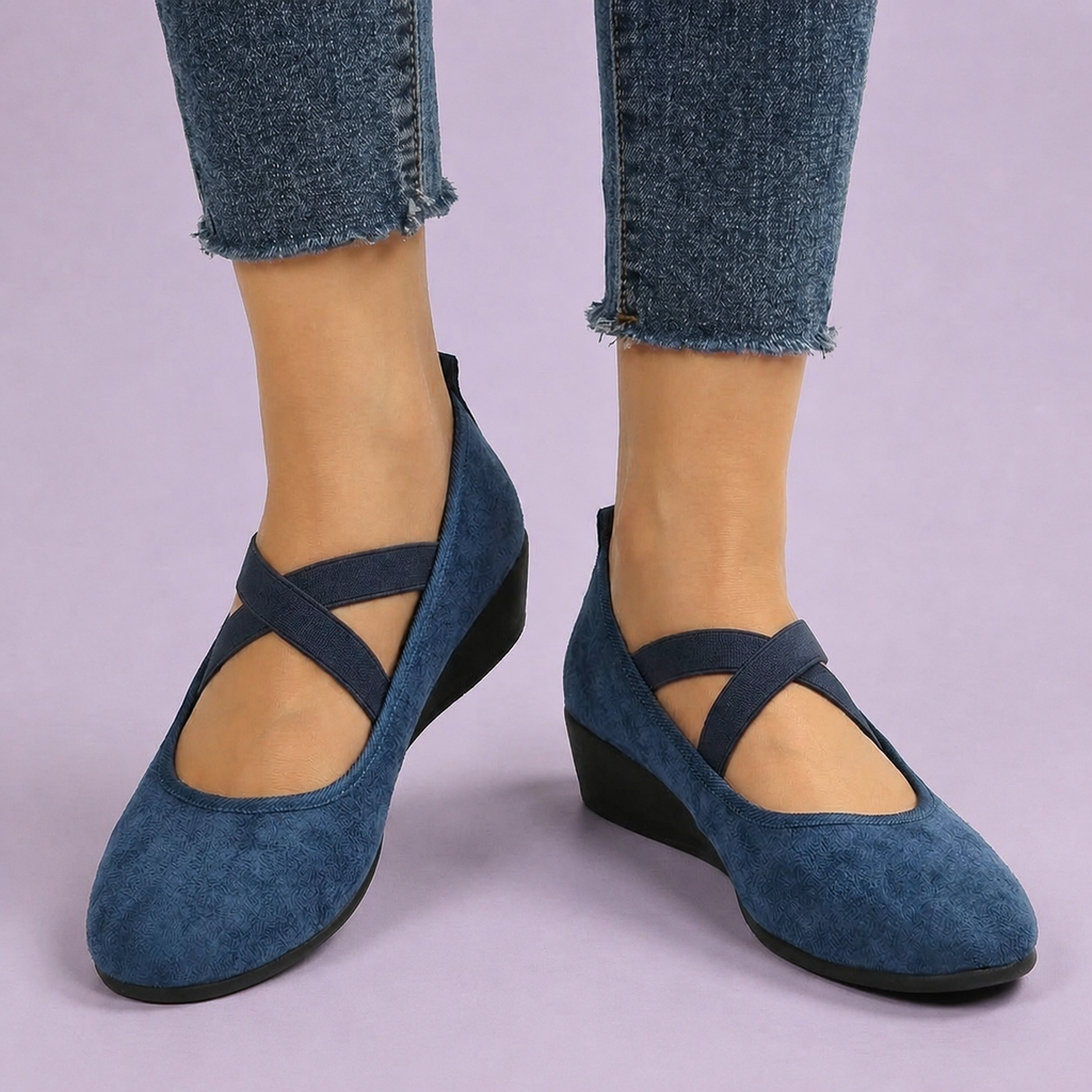 Navy slip on shoes with crossover elastic straps and low wedge soles.