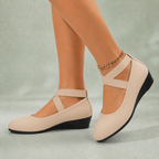 Cream suede flats on feet
