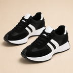 Black sneakers with white side stripes and white soles.