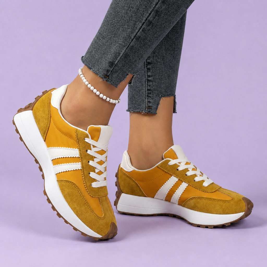 Yellow sneakers with white side stripes, worn with cropped jeans.