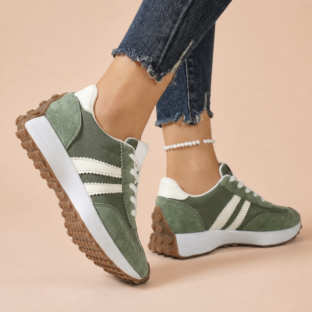 Green sneakers with white stripes and gum soles, worn on feet.