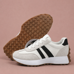 White sneakers shown from the side alongside their gum outsole tread.