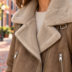 Close-up of womens suede look aviator jacket showing the collar, fastening and material texture.