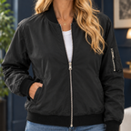 Close view of the black bomber jacket showing its silver tone zip and ribbed collar